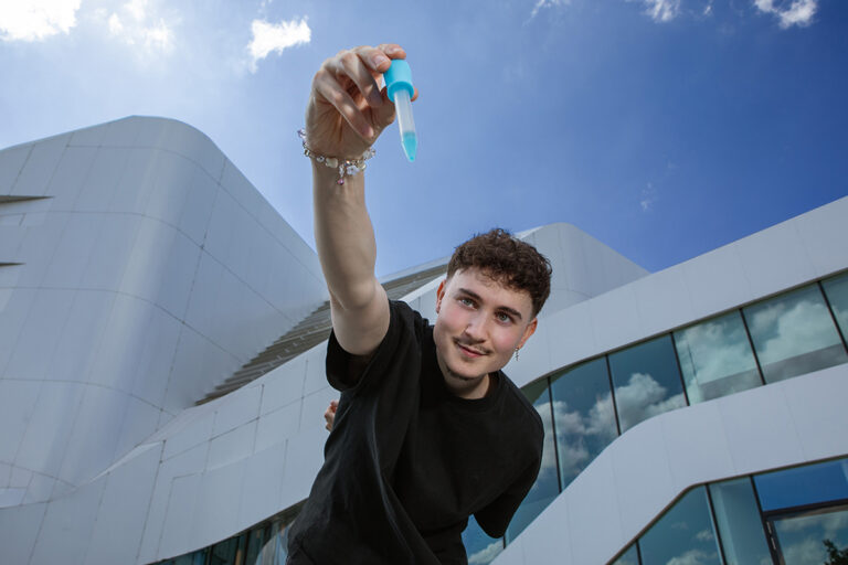 Ein Junge hält eine Pipette in der Hand.