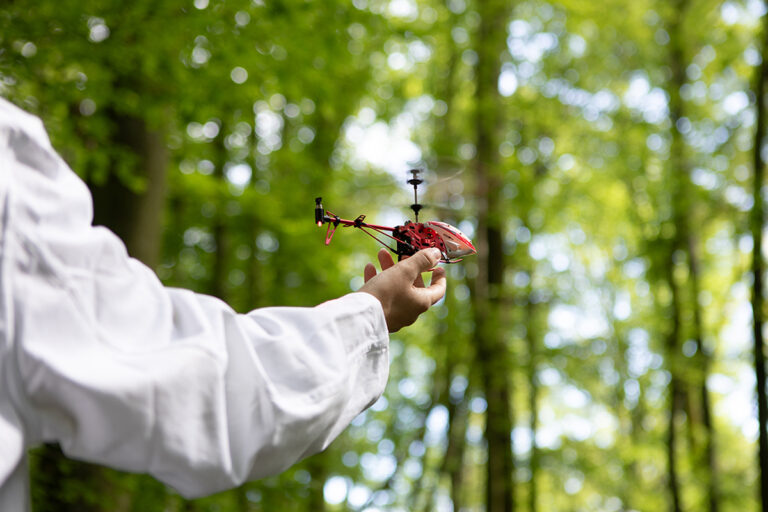 Eine Hand hält einen kleinen Helikopter.